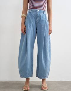 Model wearing Cocoon mid rise barrel jean in bleach