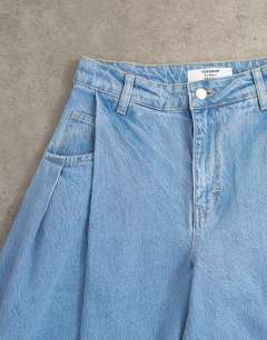 Model wearing Cocoon mid rise barrel jean in bleach