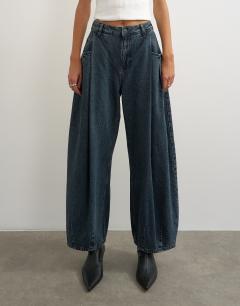 Model wearing Cocoon mid rise barrel jean in blue black