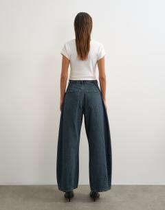 Model wearing Cocoon mid rise barrel jean in blue black