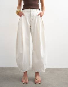 Model wearing Cocoon mid rise barrel jean in bone