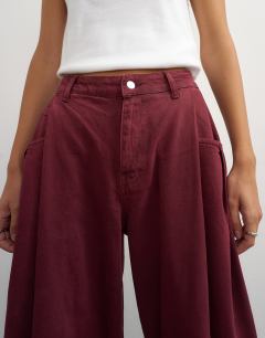 Model wearing Cocoon mid rise barrel jean in cherry red