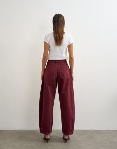 Model wearing Cocoon mid rise barrel jean in cherry red