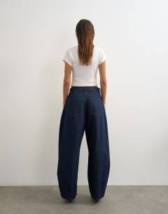 Model wearing Cocoon mid rise barrel jean in dark rinse