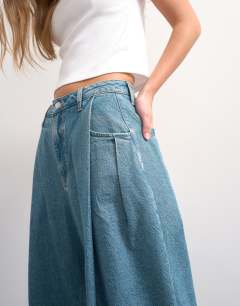 Model wearing Cocoon mid rise barrel jean in green cast - MBLUE