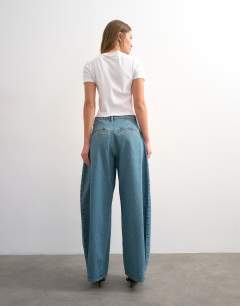 Model wearing Cocoon mid rise barrel jean in green cast