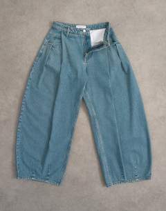 Model wearing Cocoon mid rise barrel jean in green cast
