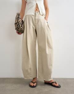 Model wearing Cocoon mid rise barrel jean in oat