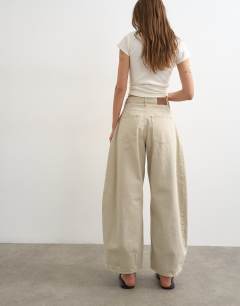 Model wearing Cocoon mid rise barrel jean in oat