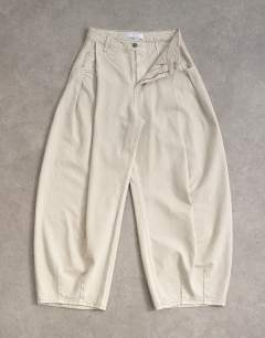 Model wearing Cocoon mid rise barrel jean in oat