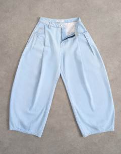 Model wearing Cocoon mid rise barrel jean in super bleach