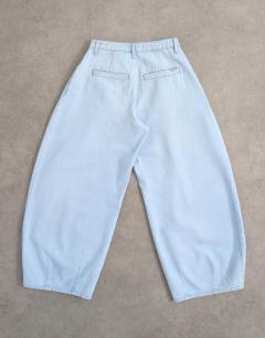 Model wearing Cocoon mid rise barrel jean in super bleach