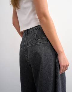Model wearing Cocoon mid rise barrel jean in washed black