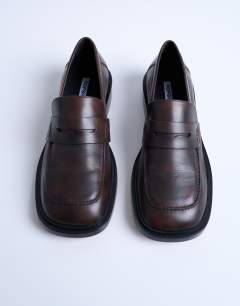 Model wearing Cole premium real leather square toe loafers in distressed brown