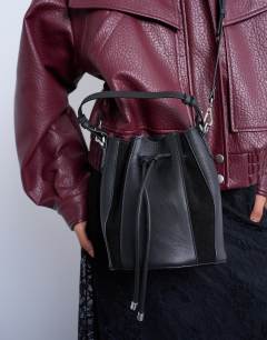 Model wearing Colette real suede and leather panel bucket bag in black