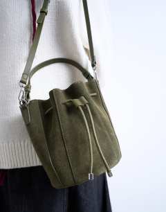 Model wearing Colette real suede bucket bag in khaki