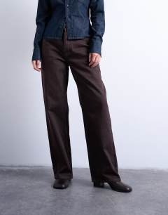 Model wearing Column mid rise jean in brown rinse