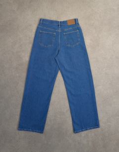 Model wearing Column mid rise jean in rich blue