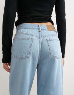 Model wearing Column mid rise jean with extreme rip in bleach