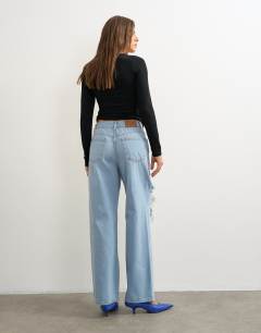 Model wearing Column mid rise jean with extreme rip in bleach