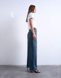 Model wearing Column mid rise jeans in deep blue