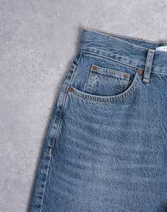 Model wearing Column mid rise jeans in deep blue