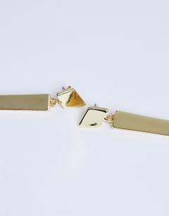 Model wearing Cora asymmetric drop stud earring in gold tone