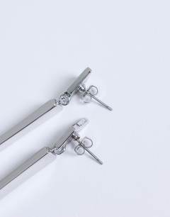 Model wearing Cora asymmetric drop stud earring in silver tone