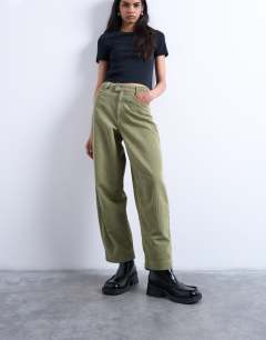 Model wearing Cord high rise barrel leg trouser in green