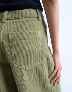 Model wearing Cord high rise barrel leg trouser in green
