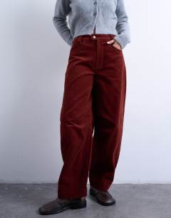 Model wearing Cord high rise barrel trouser in rust