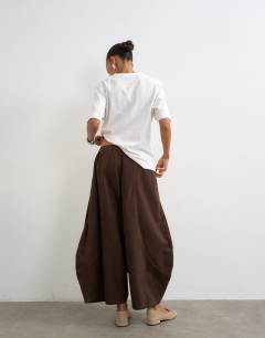 Model wearing Cord mid length ovoid trouser in chocolate