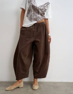Model wearing Cord mid length ovoid trouser in chocolate