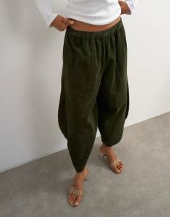 Model wearing Cord mid length ovoid trouser in green