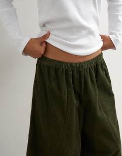 Model wearing Cord mid length ovoid trouser in green