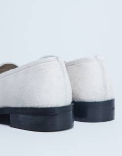 Model wearing Corrie flat shoe loafer in off white hair on real leather