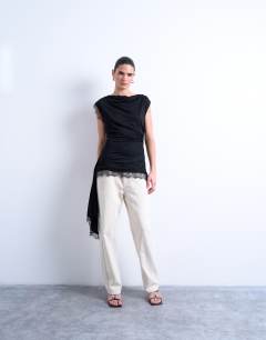 Model wearing Cowl neck lace trim top in black