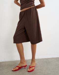 Model wearing Crinkle long line board shorts in chocolate