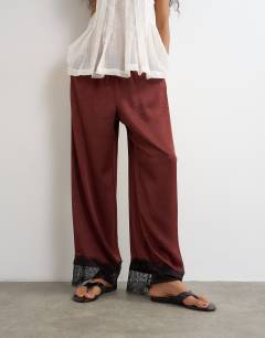 Model wearing Crinkle satin lace insert trouser in burgundy