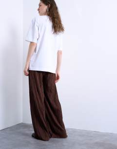Model wearing Crinkle wide leg trousers in chocolate brown