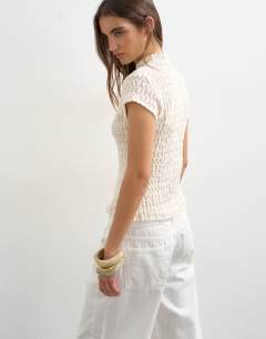 Model wearing Crochet cap sleeve button top in cream