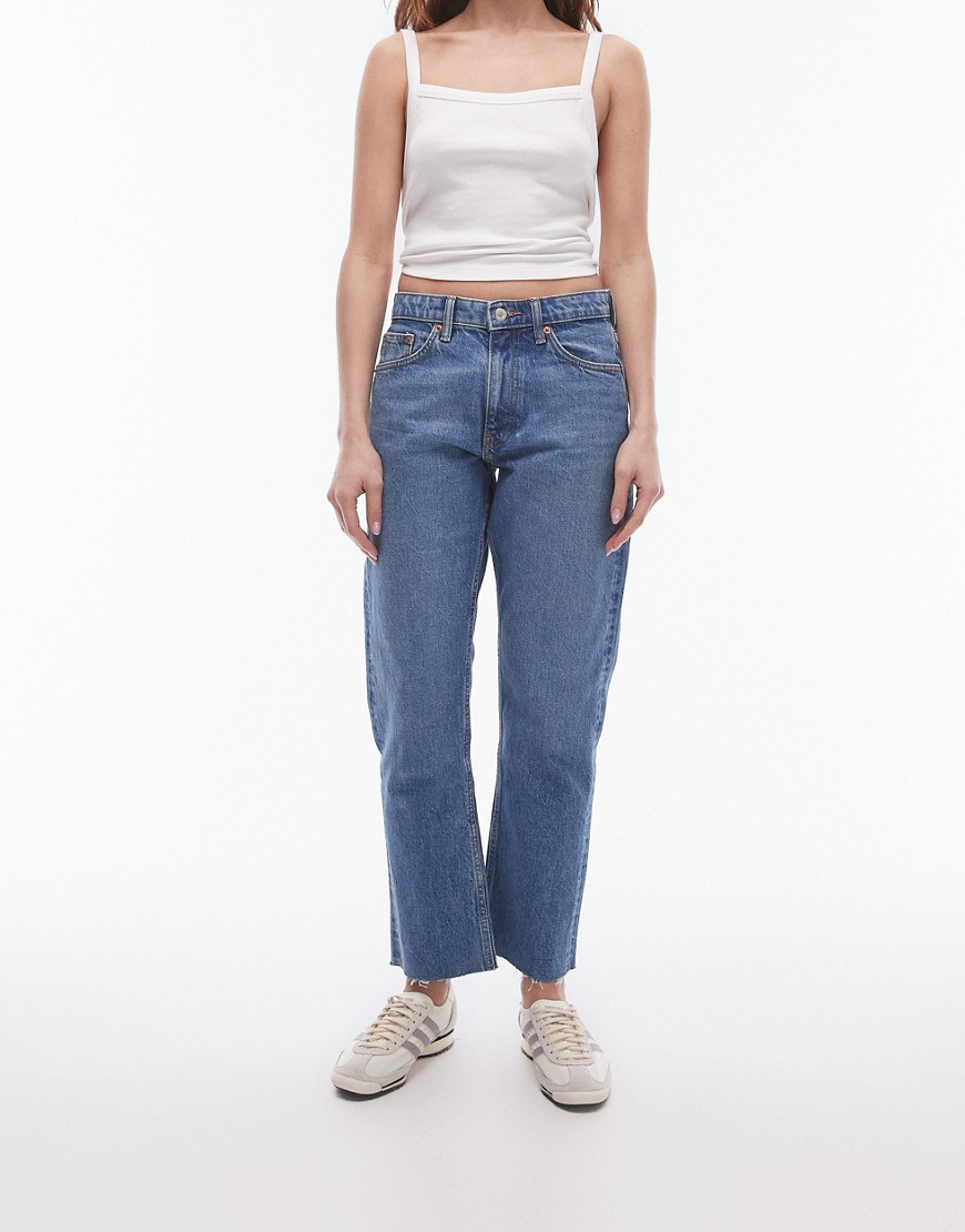 cropped mid rise straight jeans with raw hems in mid blue