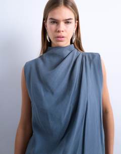 Model wearing Cupro asym hem draped tunic top in grey blue