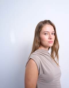 Model wearing Cupro asymmetric mini dress in pale khaki
