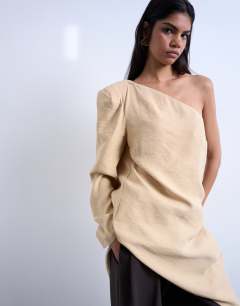 Model wearing Cupro asymmetric top with shoulder pads in stone