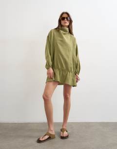 Model wearing Cupro funnel neck dropped waist long sleeve mini dress in khaki