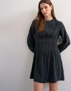 Model wearing Cupro pintucked waist mini dress in soft black