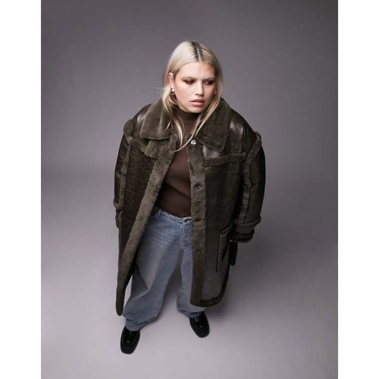 Topshop Curve faux fur long line aviator coat in dark olive. Dark olive coloured pu coat with Spread collar, Press-stud placket, Tie waist, and Side patch pockets. This aviator coat has a smooth finish with shearling-style trims. It has a relaxed fit. 