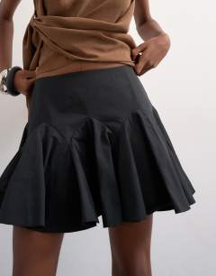 Model wearing Curved godet hem mini skirt in black