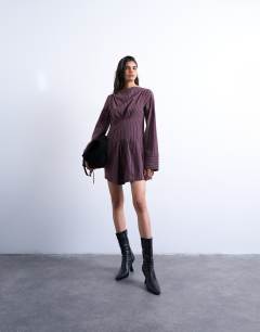 Model wearing Cut about long sleeve mini dress in burgundy stripe